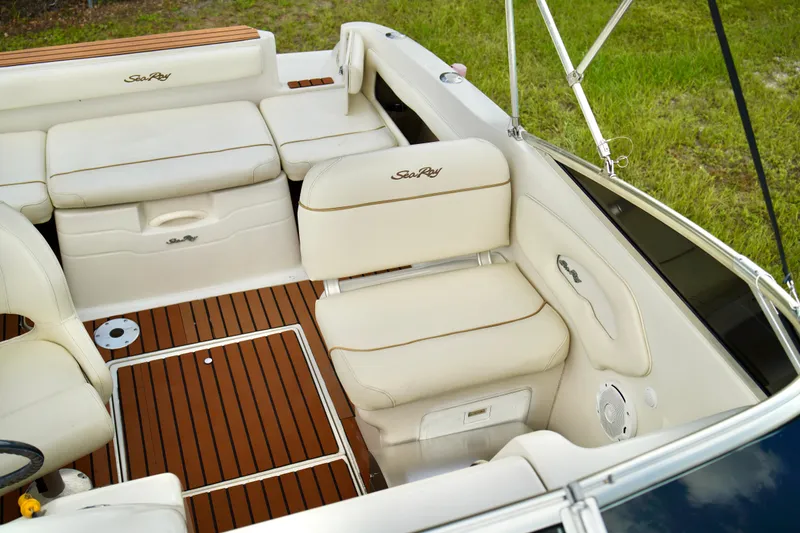 Slide: The Image of 2001 Sea Ray 215 Express Cruiser interior with white seating and teak flooring. - 9