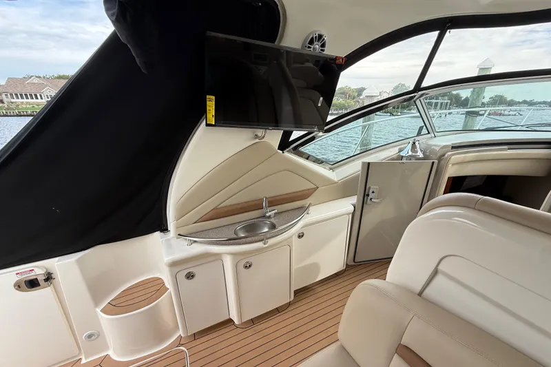 Slide: The Image of 2007 Sea Ray 40 Sundancer interior with sink, TV, and seating, overlooking water. - 6