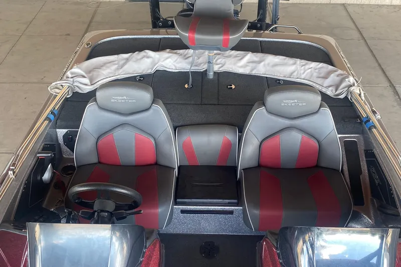 Slide: The Image of 2019 Skeeter ZX250 boat interior with gray and red seats, steering wheel, and console. - 5