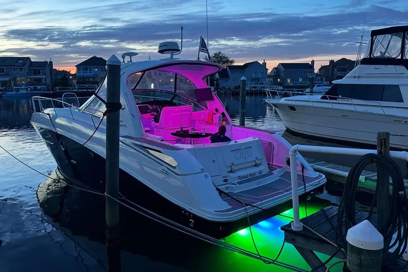 Slide: The Image of 2008 Sea Ray 350 Sundancer yacht with vibrant lights docked at sunset. - 2