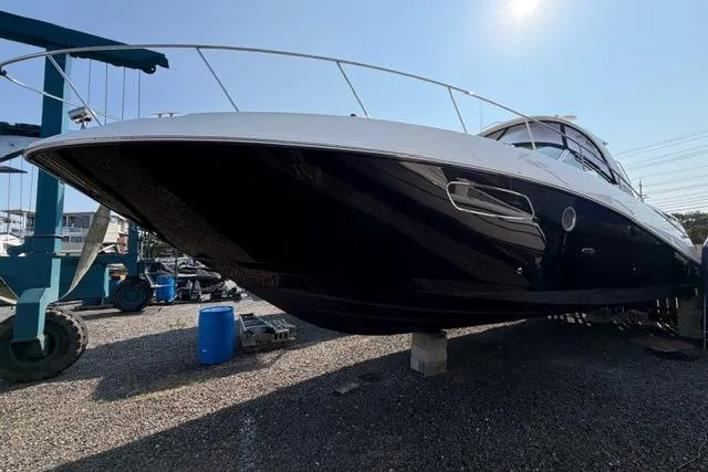 The Image of 2008 Sea Ray Sundancer 350 yacht on dry dock, side view under bright sunlight. - 0