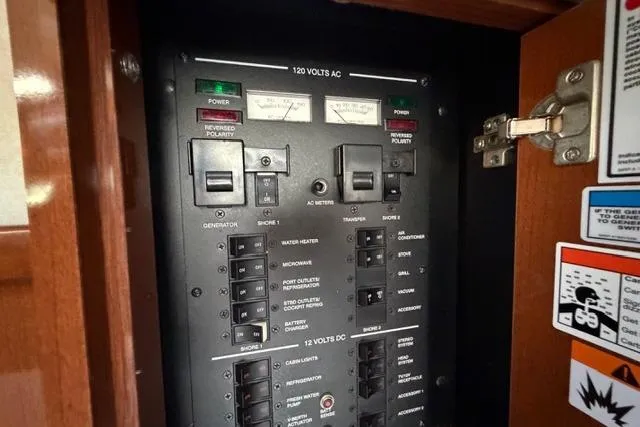 Slide: The Image of Electrical panel inside a 2008 Sea Ray Sundancer 350 boat, showing AC and DC controls. - 34