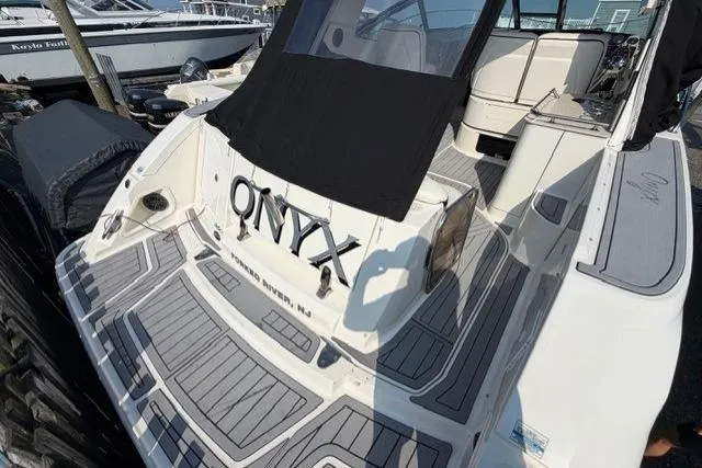 Slide: The Image of 2008 Sea Ray Sundancer 350 boat with "ONYX" name, docked, featuring sleek design and spacious deck. - 2