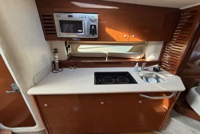 Slide: The Image of 2008 Sea Ray Sundancer 350 yacht kitchen with microwave, stove, and sink. - 24