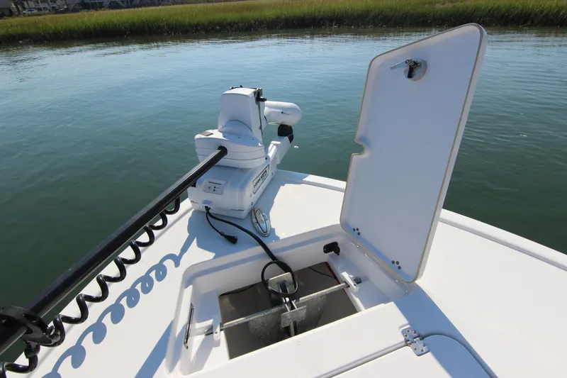 Slide: The Image of 2021 Sportsman Masters 267OE Bay Boat with open hatch and trolling motor on calm water. - 11