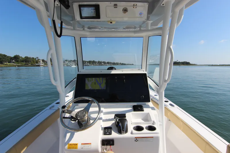 Slide: The Image of 2021 Sportsman Masters 267OE Bay Boat dashboard with steering wheel and navigation screen. - 17