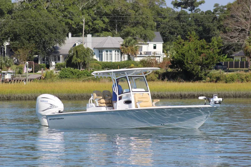 Slide: The Image of 2021 Sportsman Masters 267OE Bay Boat on calm water near lush shoreline. - 4