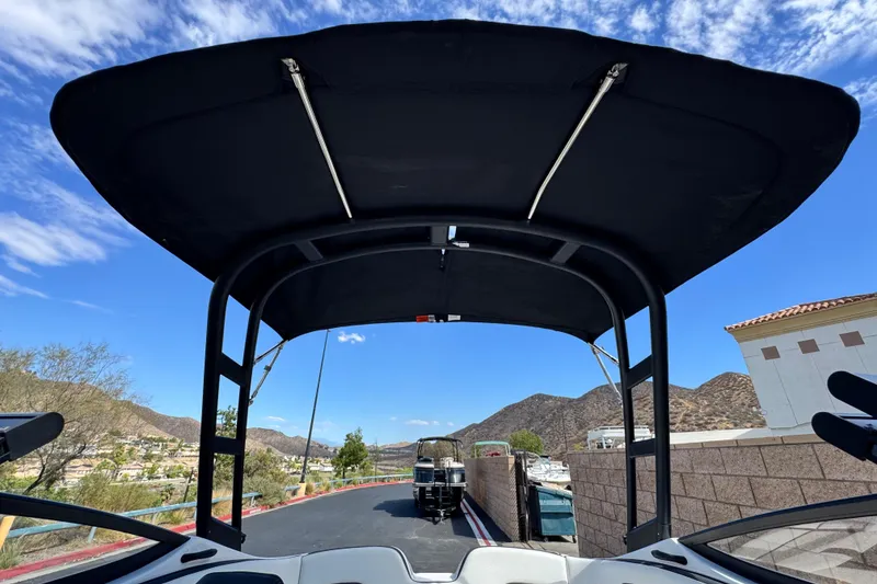 Slide: The Image of 2019 Yamaha AR210 boat with canopy, scenic mountain backdrop, clear blue sky. - 12