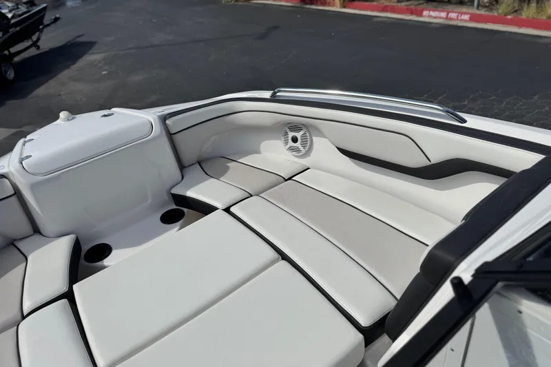 Slide: The Image of 2019 Yamaha Boats AR210 interior with white seating and speaker system. - 16
