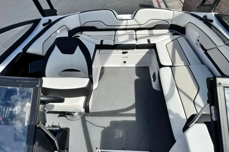 Slide: The Image of 2019 Yamaha AR210 boat interior with white and black seating, steering wheel, and carpeted floor. - 17