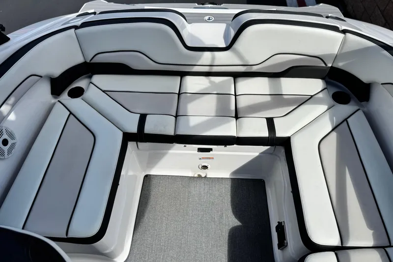 Slide: The Image of 2019 Yamaha AR210 boat interior with white cushioned seating and gray flooring. - 18