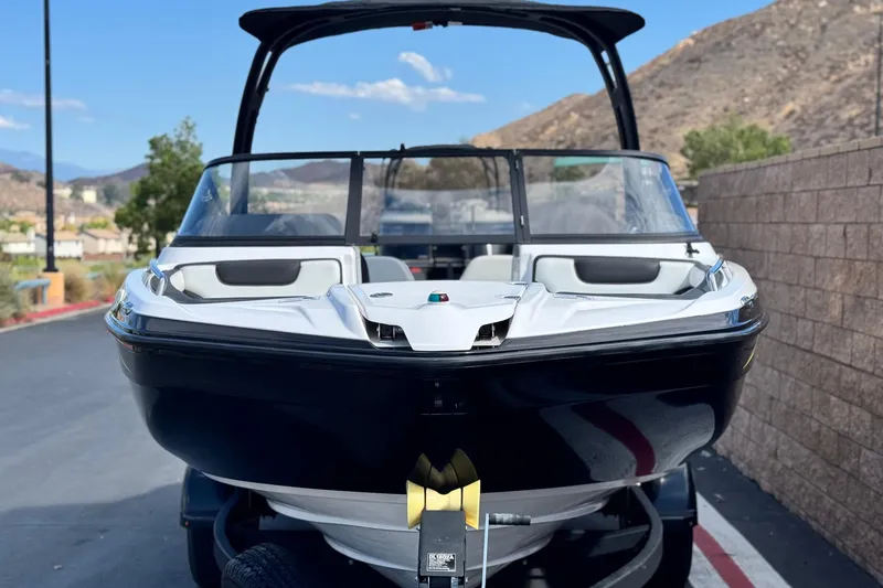 Slide: The Image of 2019 Yamaha Boats AR210, sleek design, parked outdoors with scenic mountain backdrop. - 2
