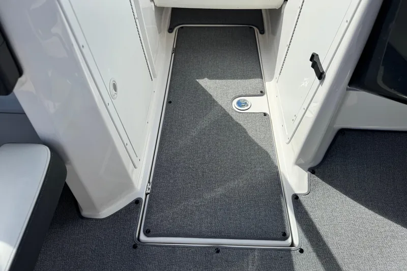 Slide: The Image of 2019 Yamaha AR210 boat interior with gray carpeted flooring and storage compartments. - 23