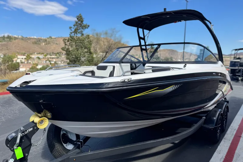 Slide: The Image of 2019 Yamaha Boats AR210 on trailer, sleek black and white design, parked outdoors. - 3