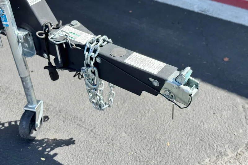 Slide: The Image of Trailer hitch of a 2019 Yamaha Boats AR210 with safety chains on asphalt. - 31