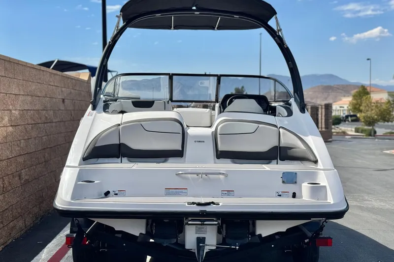 Slide: The Image of 2019 Yamaha AR210 boat, rear view, parked outdoors with mountains in background. - 4