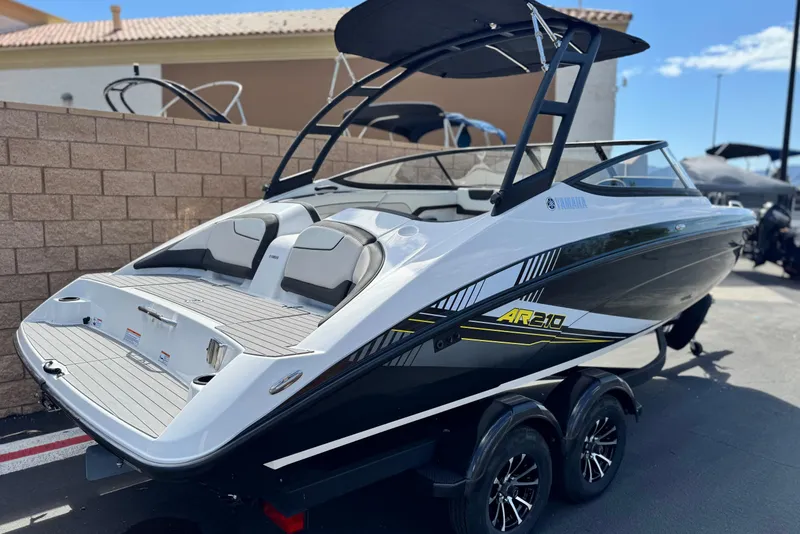 Slide: The Image of 2019 Yamaha AR210 boat with sleek design and dual seating, parked outdoors. - 5