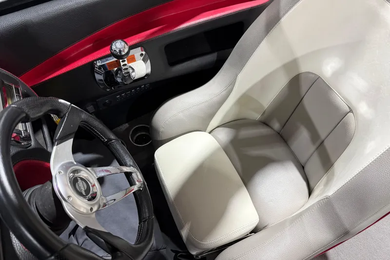 Slide: The Image of Interior of a 2009 Malibu Wakesetter 23 LSV boat, featuring a sleek steering wheel and comfortable seat. - 14