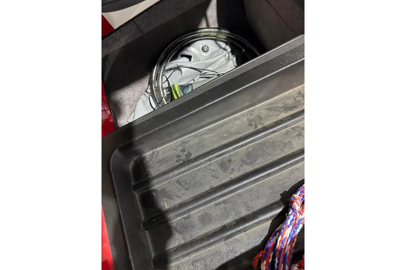 Slide: The Image of Storage compartment in a 2009 Malibu Wakesetter 23 LSV with coiled cables and colorful rope. - 20