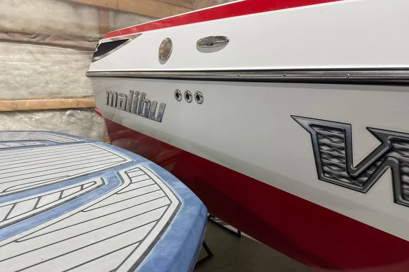 Slide: The Image of 2009 Malibu Wakesetter 23 LSV boat in storage, showcasing sleek design and branding. - 30