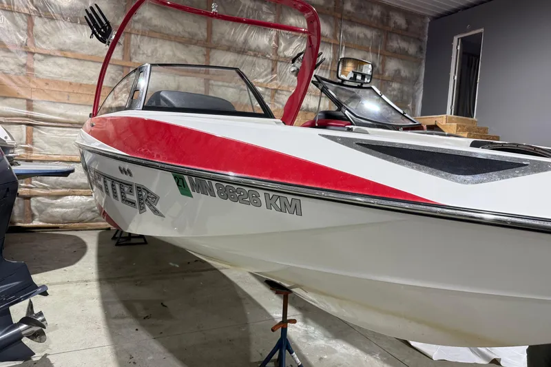 Slide: The Image of 2009 Malibu Wakesetter 23 LSV boat with red accents in a garage setting. - 33