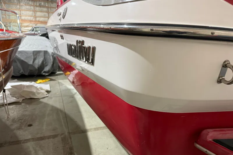 Slide: The Image of 2009 Malibu Wakesetter 23 LSV boat in storage, featuring red and white exterior. - 37