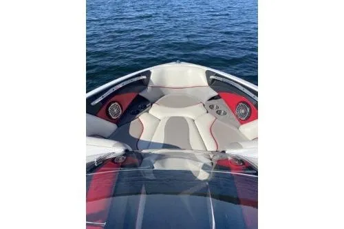 Slide: The Image of 2009 Malibu Wakesetter 23 LSV boat interior with red and gray seating on water. - 4