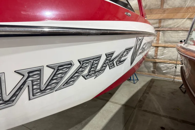 Slide: The Image of 2009 Malibu Wakesetter 23 LSV boat with bold graphics in a storage facility. - 41