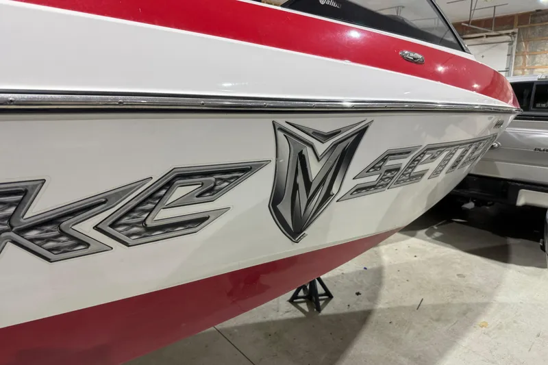 Slide: The Image of 2009 Malibu Wakesetter 23 LSV boat with red and white exterior in a garage. - 47