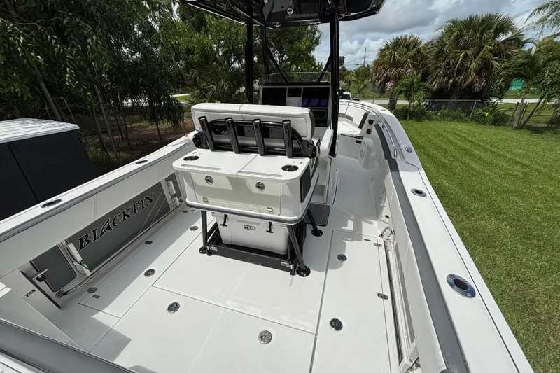 Slide: The Image of 2020 Blackfin 252 CC boat interior with seating and console, surrounded by greenery. - 10