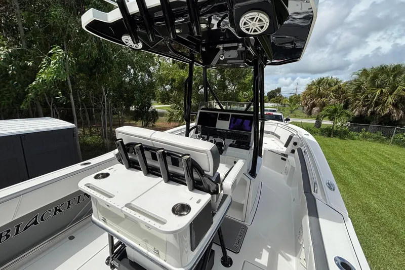 Slide: The Image of 2020 Blackfin 252 CC boat interior with helm, seating, and fishing rod holders. - 11