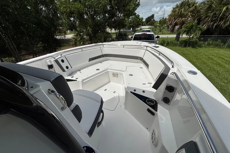 Slide: The Image of 2020 Blackfin 252 CC boat interior with seating and storage, parked on grass. - 13