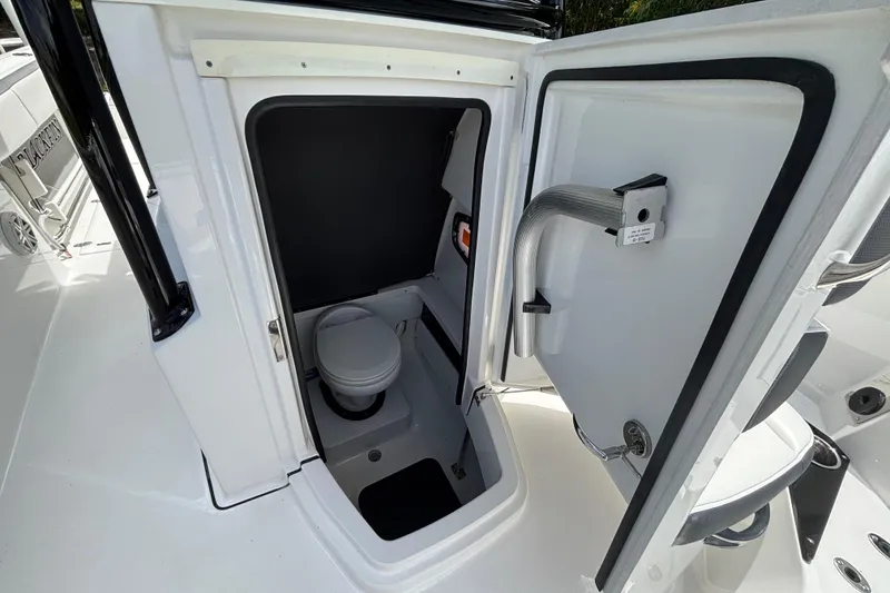 Slide: The Image of 2020 Blackfin 252 CC boat interior with open door revealing compact marine toilet. - 17