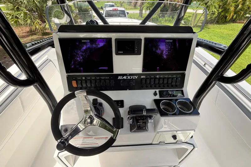 Slide: The Image of 2020 Blackfin 252 CC boat dashboard with dual Simrad displays and steering wheel. - 22