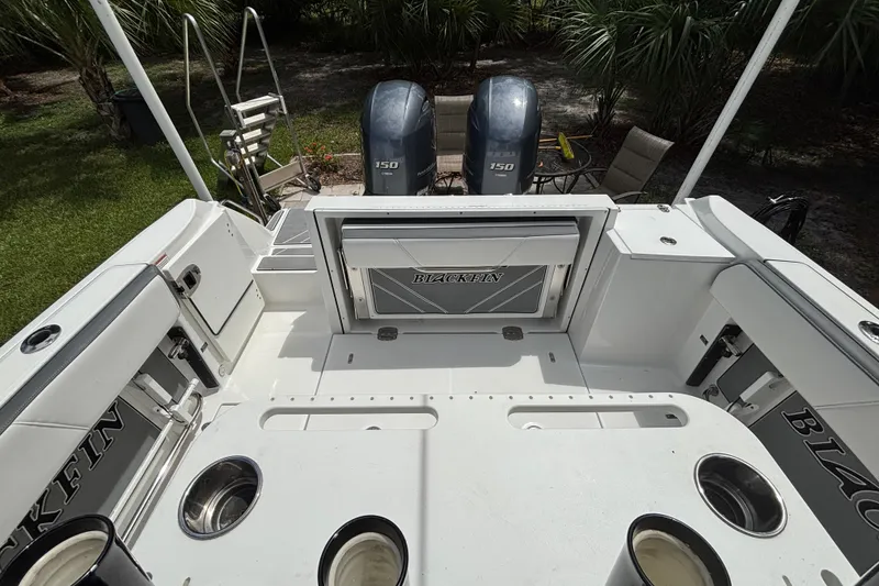 Slide: The Image of 2020 Blackfin 252 CC boat interior with dual 150 engines, white seating, and fishing rod holders. - 24