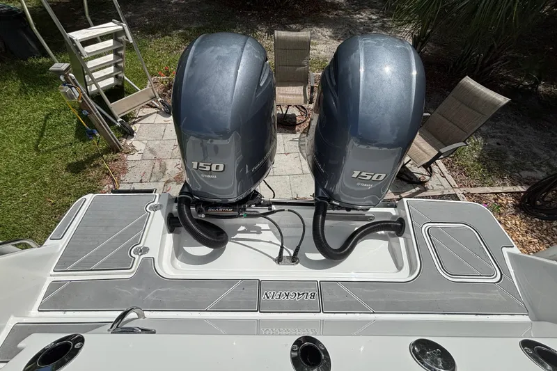 Slide: The Image of 2020 Blackfin 252 CC boat with dual Yamaha 150 engines, docked on a sunny day. - 27