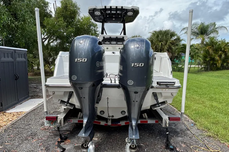 Slide: The Image of 2020 Blackfin 252 CC boat with dual Yamaha 150 outboard engines, parked outdoors. - 7