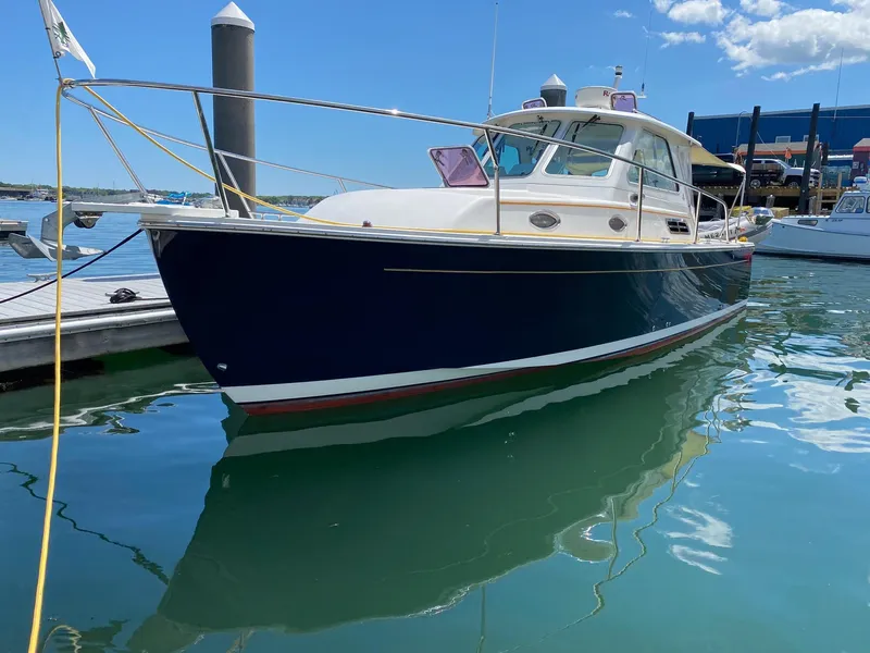 Slide: The Image of 2007 Back Cove 29 boat docked in a marina under a clear blue sky. - 0