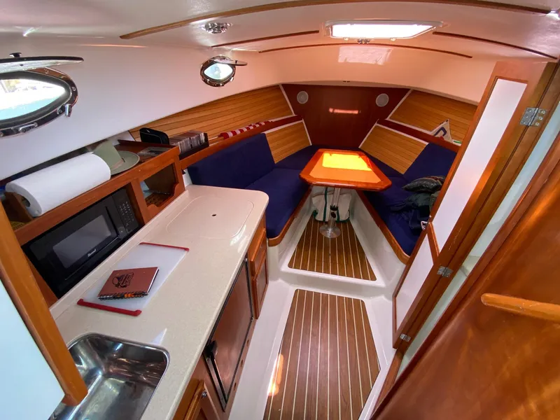 Slide: The Image of 2007 Back Cove 29 interior with kitchenette, seating, and wooden accents. - 1