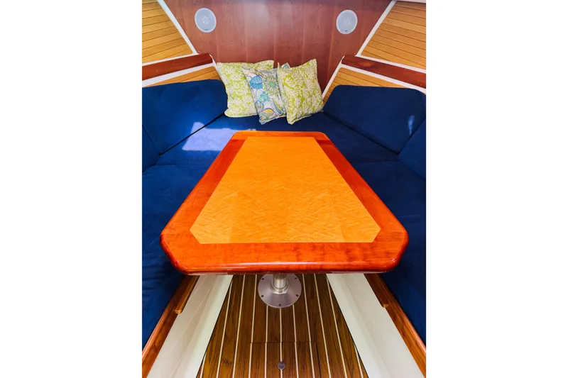 Slide: The Image of 2007 Back Cove 29 interior with wooden table, blue seating, and decorative pillows. - 2