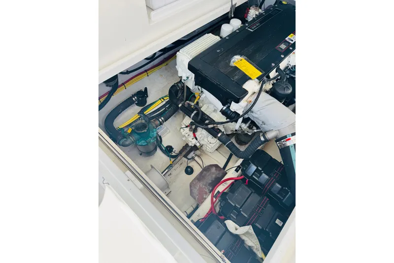 Slide: The Image of Engine compartment of a 2007 Back Cove 29 boat, showcasing mechanical components and wiring. - 21