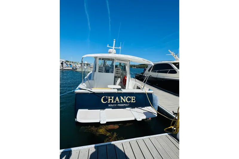 Slide: The Image of 2007 Back Cove 29 boat named "Chance" docked at marina, clear blue sky. - 35