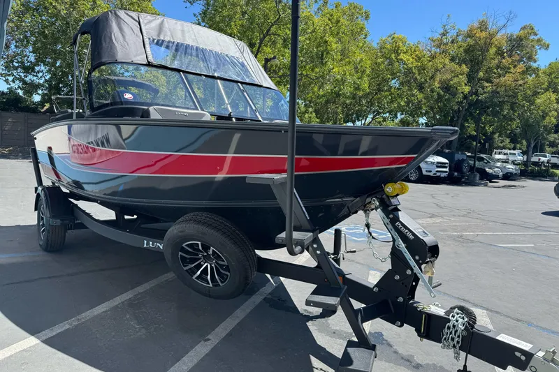 Slide: The Image of 2026 Lund 1775 Crossover XS boat on trailer in parking lot, sunny day. - 2
