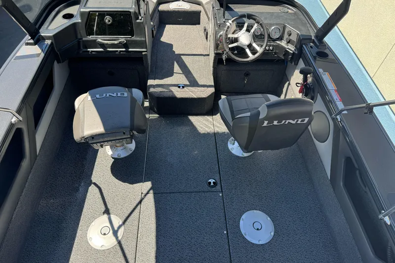 Slide: The Image of 2026 Lund 1775 Crossover XS boat interior with seating and steering console. - 6
