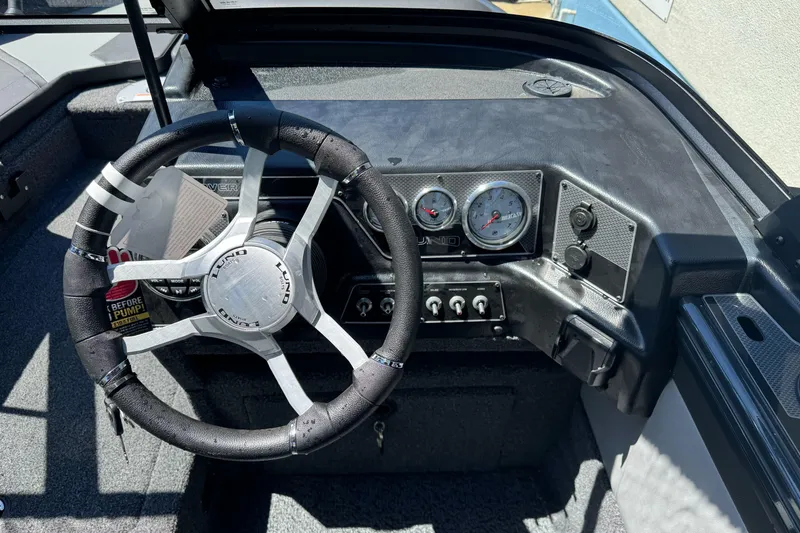 Slide: The Image of 2026 Lund 1775 Crossover XS boat dashboard with steering wheel and gauges. - 8