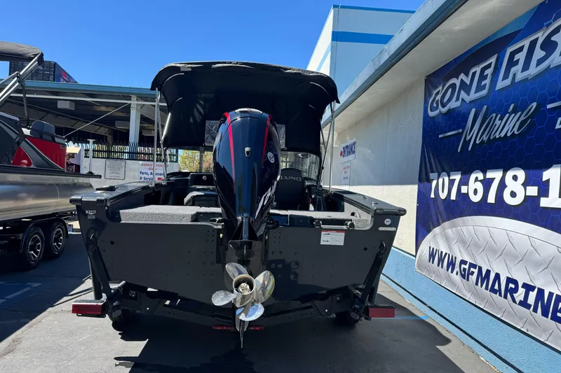 Slide: The Image of 2026 Lund 1775 Crossover XS boat displayed at a marine dealership. - 4