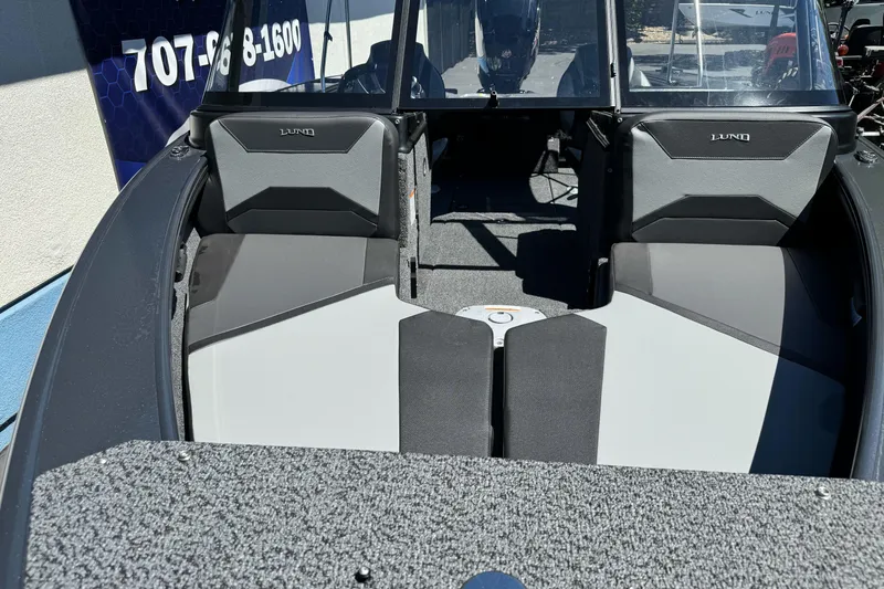 Slide: The Image of 2026 Lund 1775 Crossover XS boat interior with seating and windshield, showcasing modern design. - 19