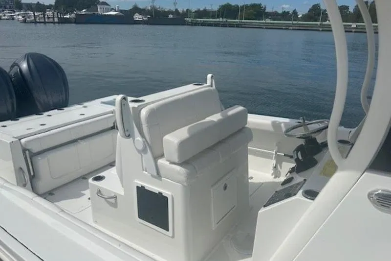 Slide: The Image of 2025 Parker 2900 Center Console boat interior with seating and steering wheel, docked by the water. - 19