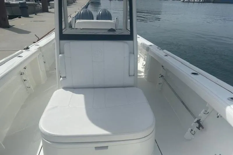 Slide: The Image of 2025 Parker 2900 Center Console boat interior with white seating, docked by the water. - 8
