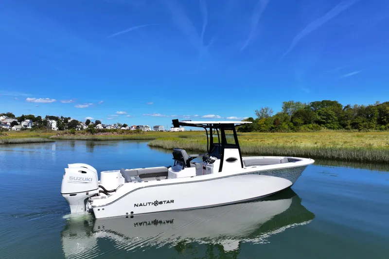 The Image of 2026 NauticStar 252 Legacy boat on calm water under clear blue sky. - 1